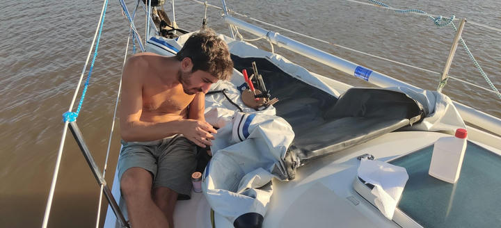 Work on the dinghy, Yalcin at the bow